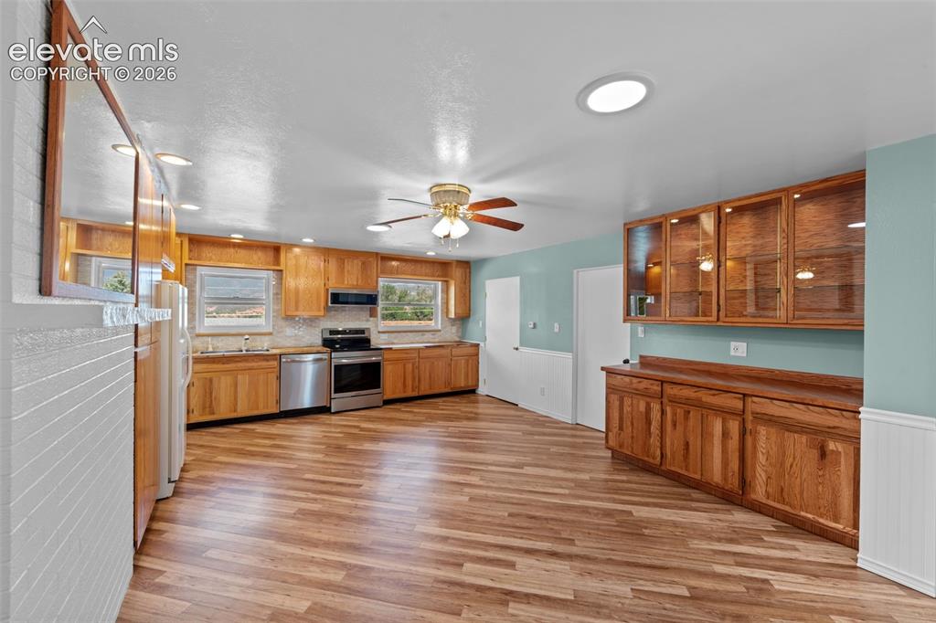 Image 13 of 34: Spacious kitchen featuring wood-finish flooring, extensive wood cabinetry, 