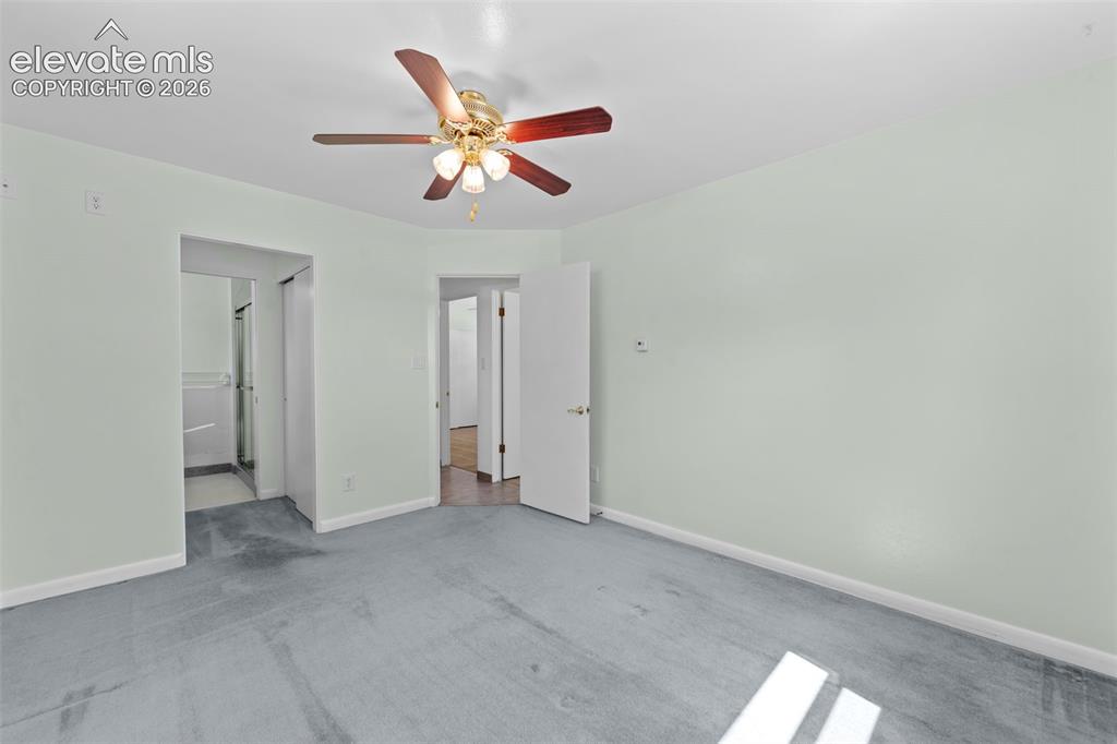 Image 18 of 34: Spacious room featuring light-toned walls, a ceiling fan with light fixture