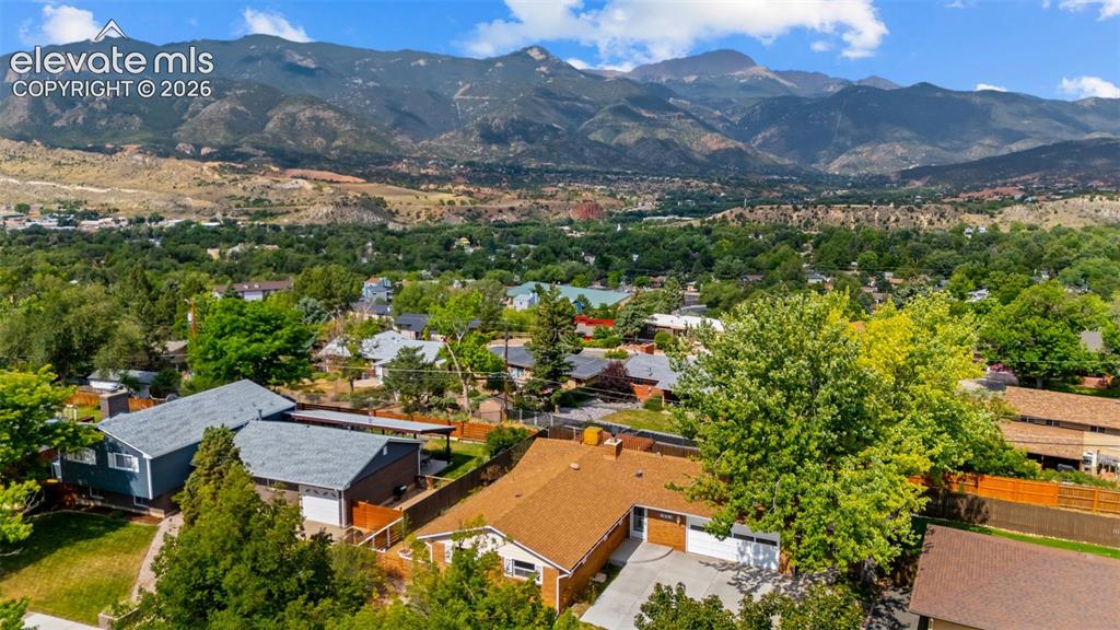 Image 30 of 34: Mountain backdrop with a residential neighborhood featuring established tre