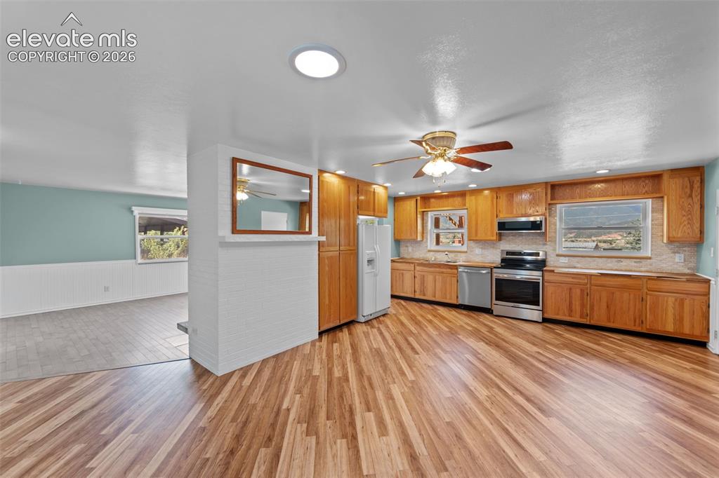 Image 5 of 34: Kitchen featuring wood-finish flooring, natural wood cabinetry, stainless s