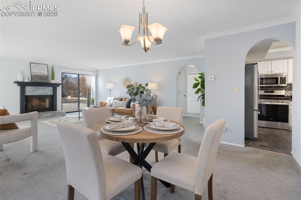 Image 13 of 31: Dining area featuring arched walkways, ornamental molding, carpet, a premiu