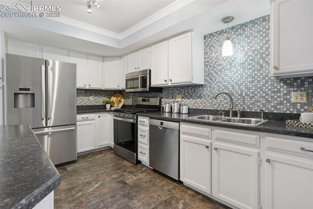 Image 16 of 31: Kitchen with appliances with stainless steel finishes, dark countertops, wh