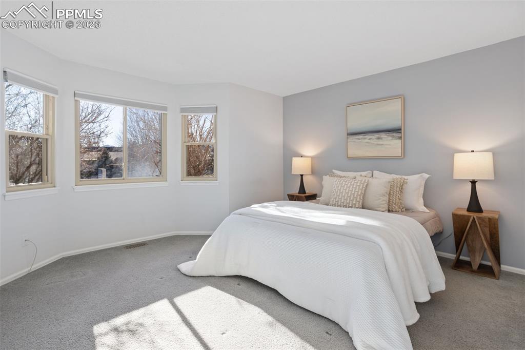 Image 17 of 31: Carpeted bedroom w/ bay window