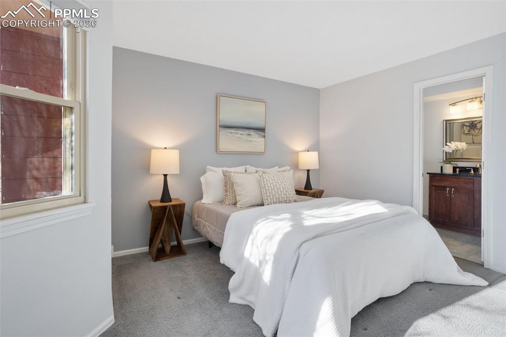 Image 18 of 31: Carpeted principal bedroom featuring carpet floors, natural light and en su