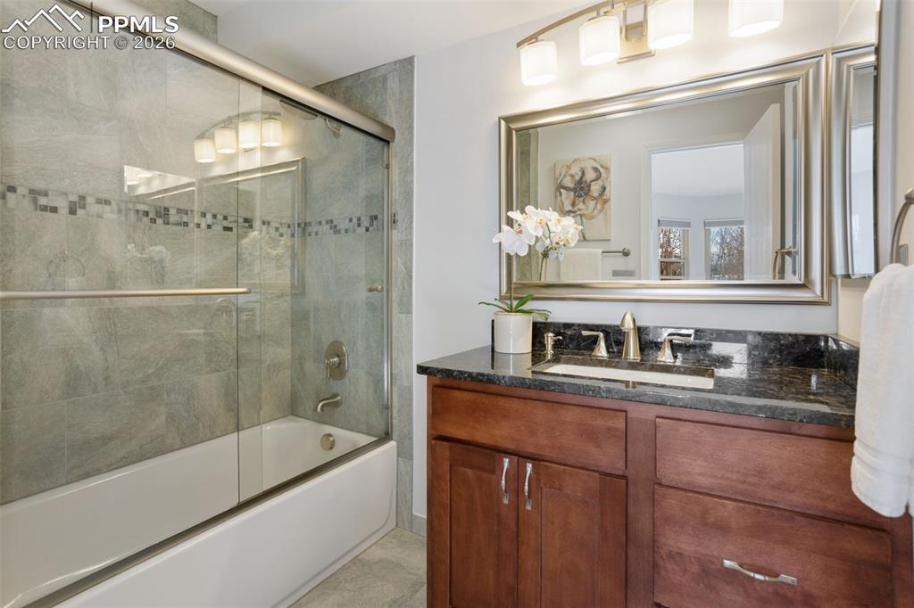 Image 19 of 31: Bathroom featuring combined bath / shower with glass door and vanity