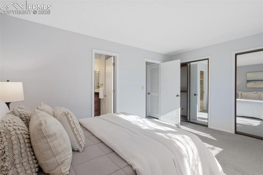 Image 20 of 31: Carpeted bedroom with closets and ensuite bathroom