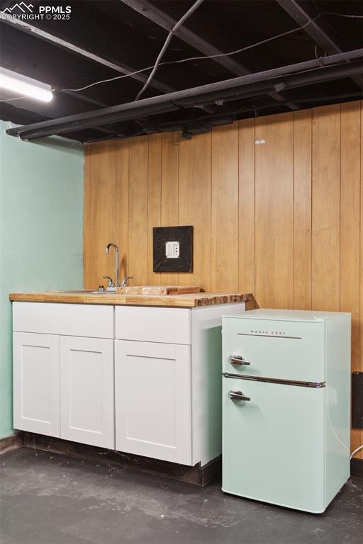 Image 12 of 48: wet bar in the basement, exterior entrance, extra storage