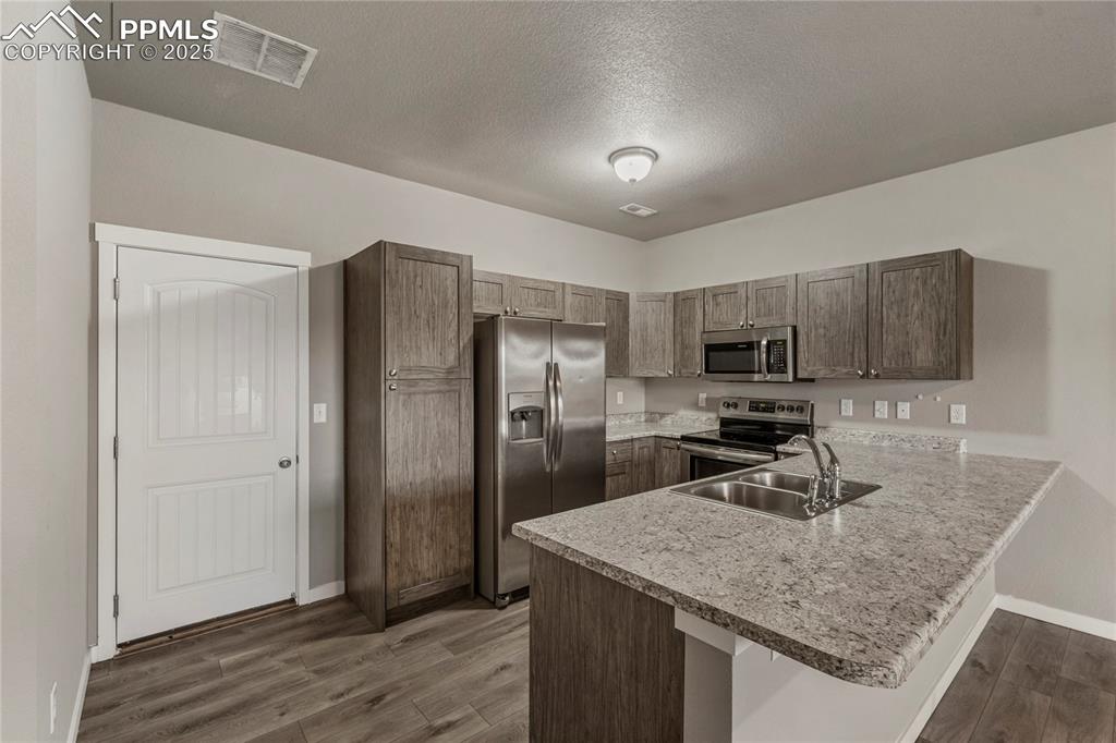 Image 10 of 29: Kitchen with stainless steel appliances, light countertops, a peninsula, a 