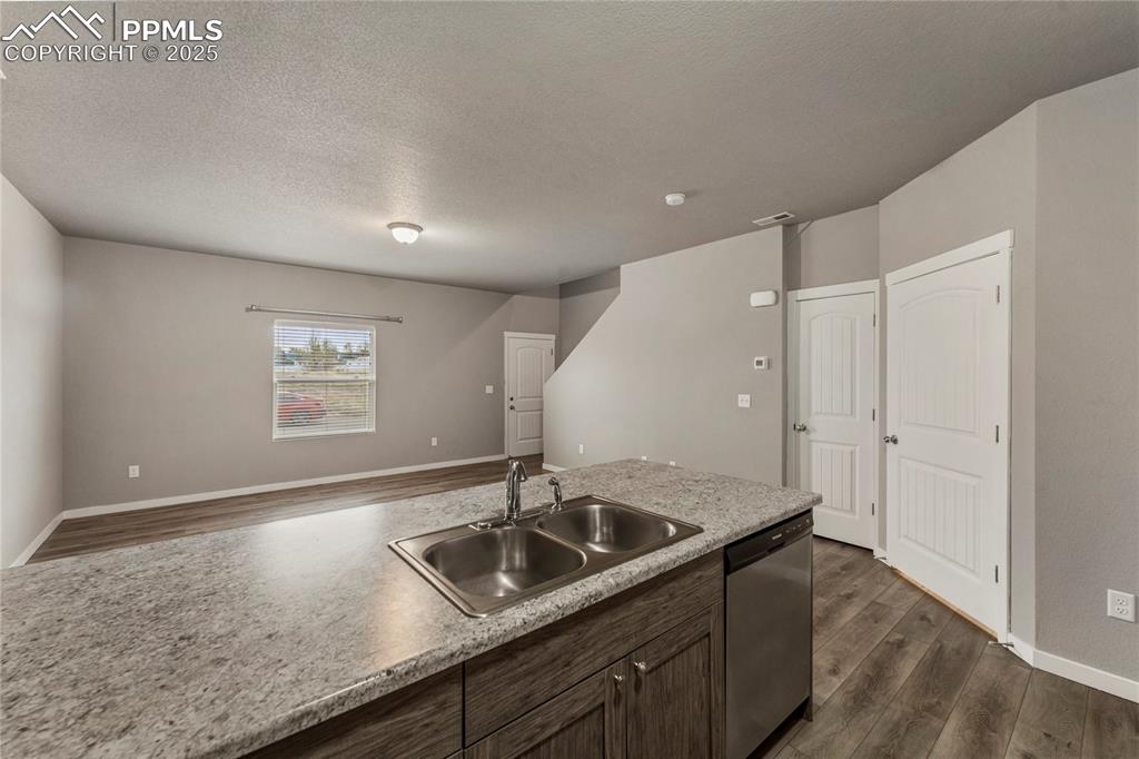 Image 13 of 29: Kitchen with dark wood-type flooring, light countertops, stainless steel di