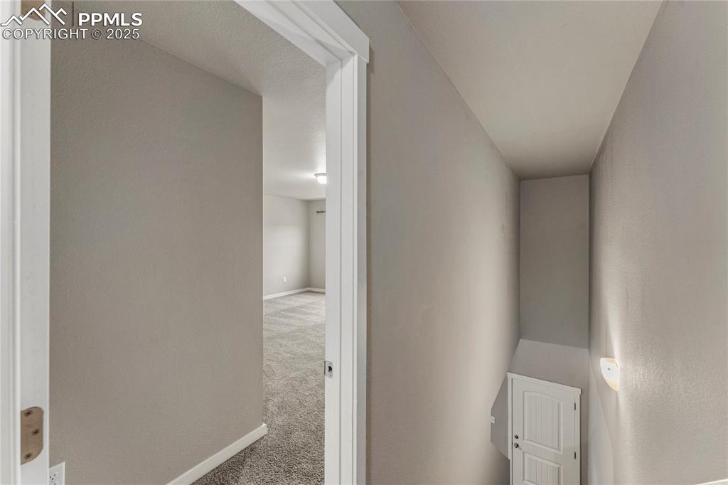 Image 16 of 29: Corridor with carpet floors and baseboards