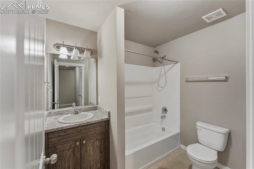 Image 27 of 29: Full bathroom with bathtub / shower combination, vanity, light tile pattern