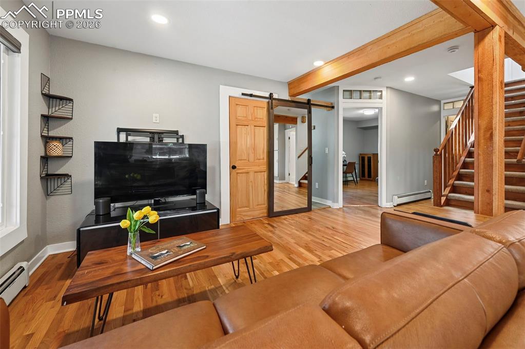 Image 9 of 40: beautiful hardwoods and beams in living room