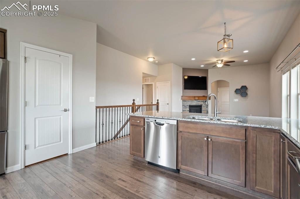 Image 13 of 45: Kitchen featuring ceiling fan, a stone fireplace, stainless steel appliance