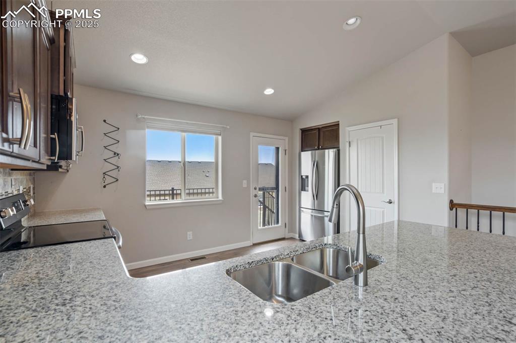 Image 15 of 45: Kitchen with dark brown cabinets, appliances with stainless steel finishes,