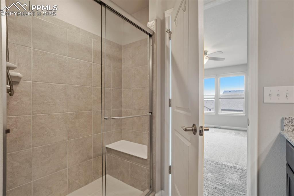Image 23 of 45: Full bathroom with a shower stall, vanity, and ceiling fan