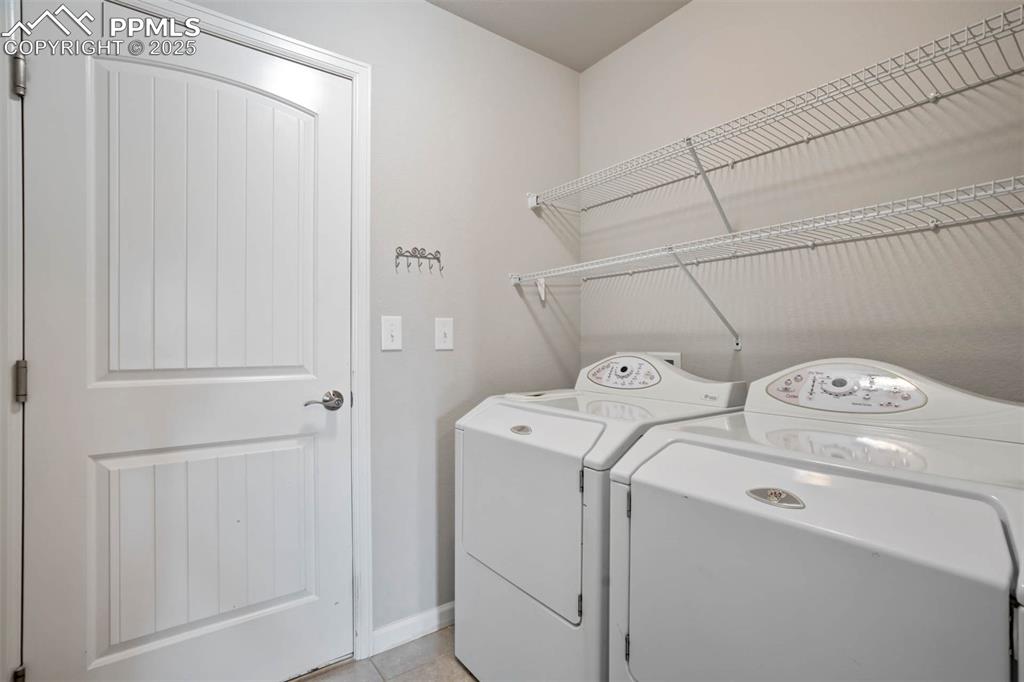 Image 25 of 45: Laundry room with separate washer and dryer and light tile patterned floori