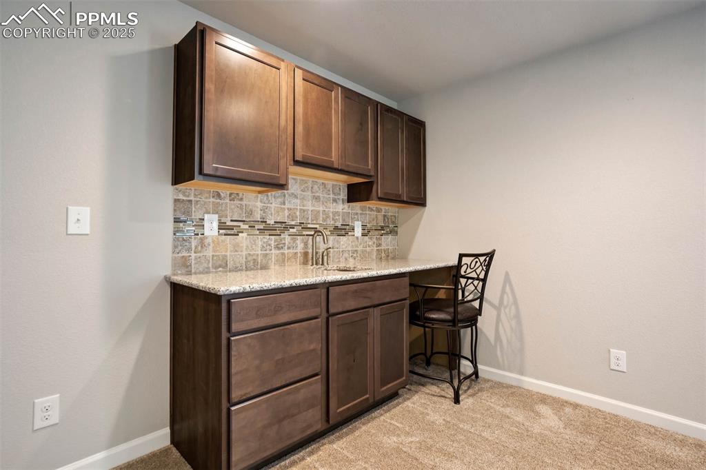 Image 28 of 45: Bar area with light colored carpet and backsplash