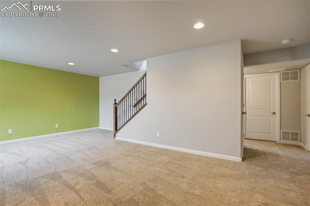 Image 29 of 45: Carpeted empty room with recessed lighting and stairway