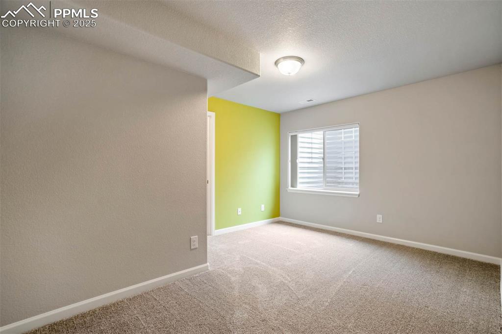 Image 31 of 45: Carpeted spare room with baseboards and a textured ceiling