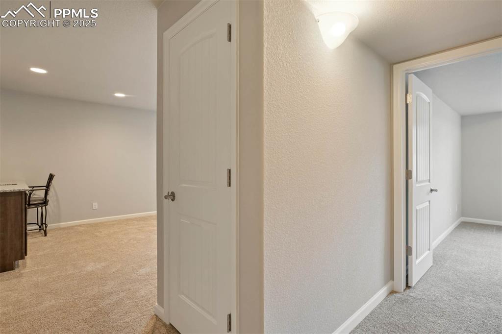 Image 33 of 45: Corridor with light carpet and recessed lighting
