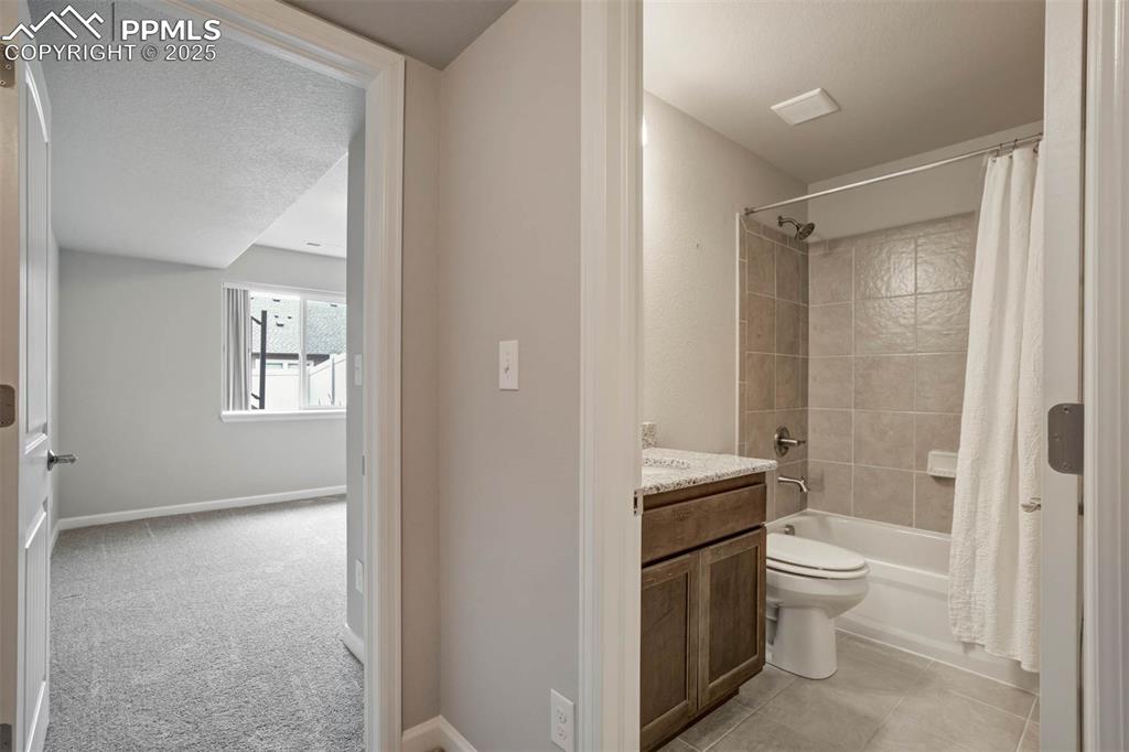 Image 34 of 45: Bathroom with shower / bath combo with shower curtain and vanity