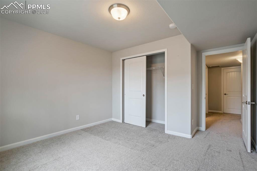 Image 36 of 45: Unfurnished bedroom with light carpet and a closet