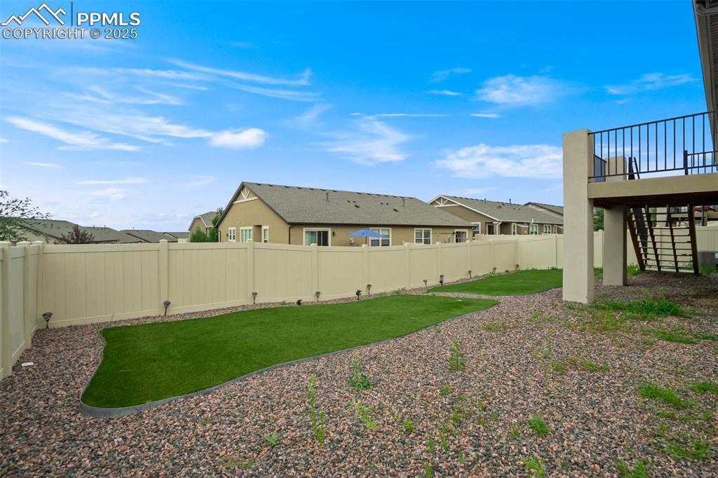 Image 43 of 45: Fenced backyard featuring stairs and a residential view