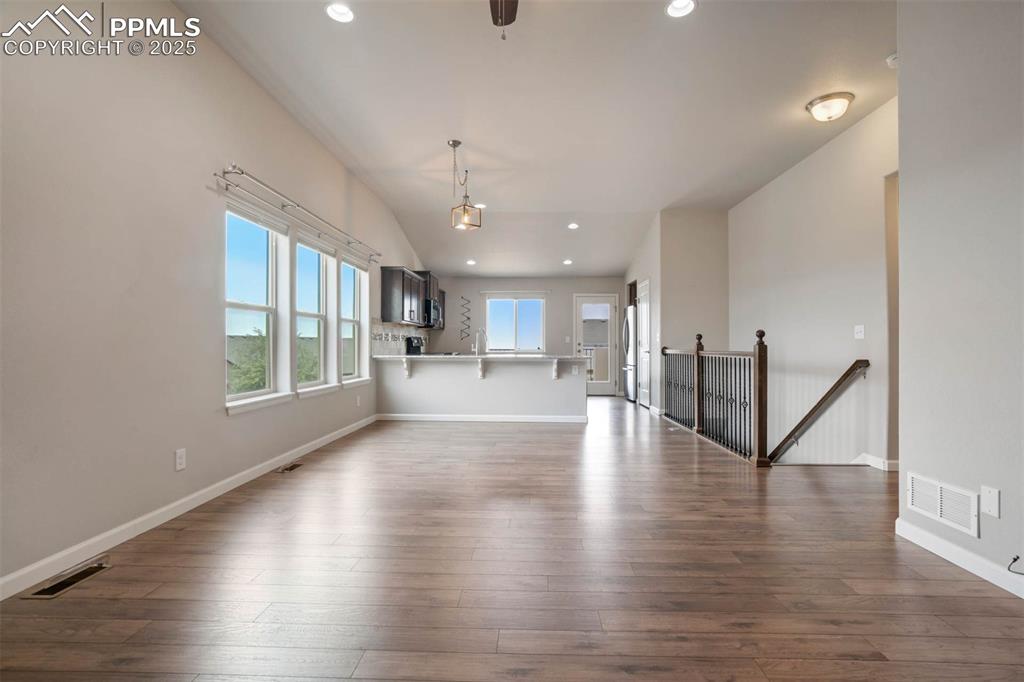 Image 7 of 45: Unfurnished living room with recessed lighting, dark wood-style flooring, a