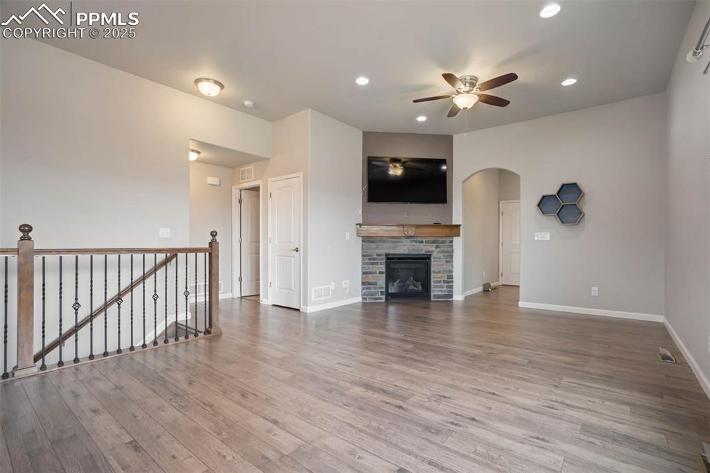 Image 9 of 45: Unfurnished living room with ceiling fan, wood finished floors, recessed li
