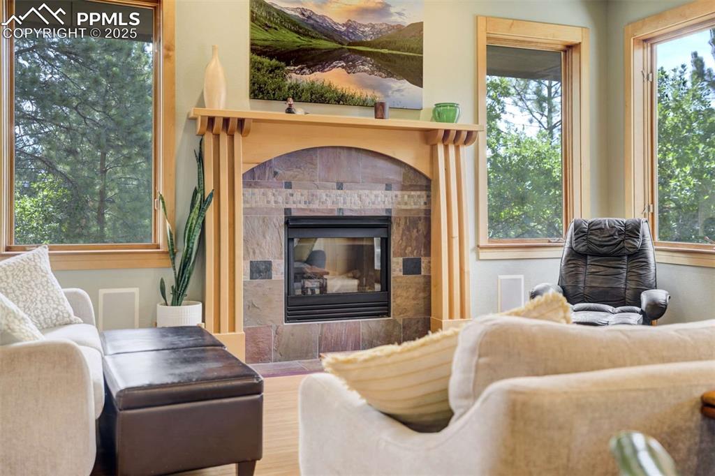 Image 12 of 50: Living room featuring a tiled fireplace and wood finished mantle