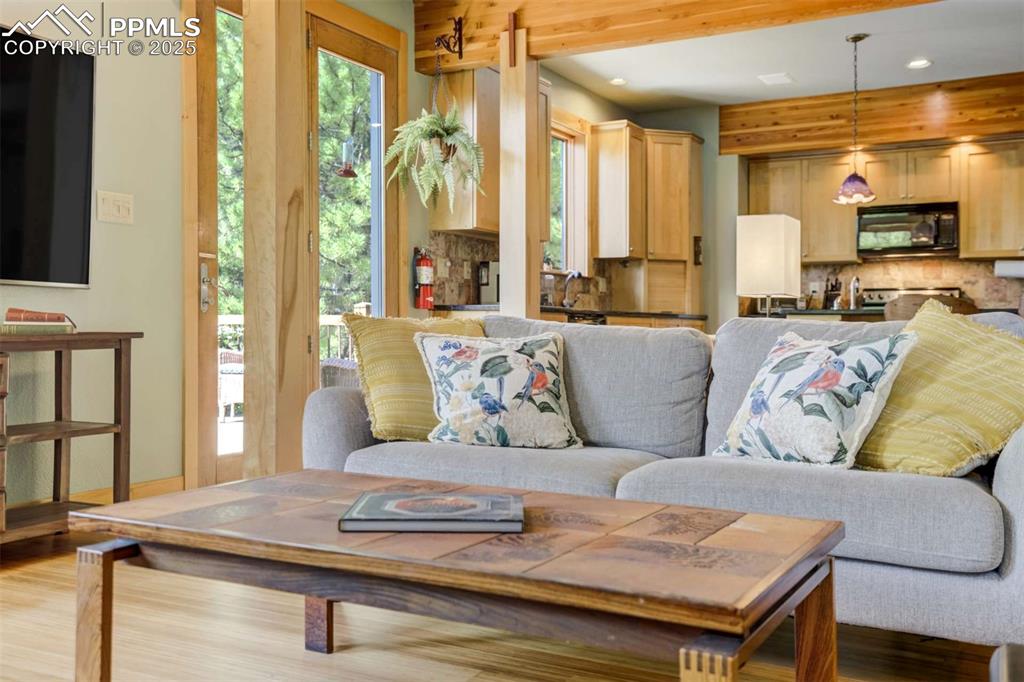 Image 14 of 50: Living room with recessed lighting and wood beams