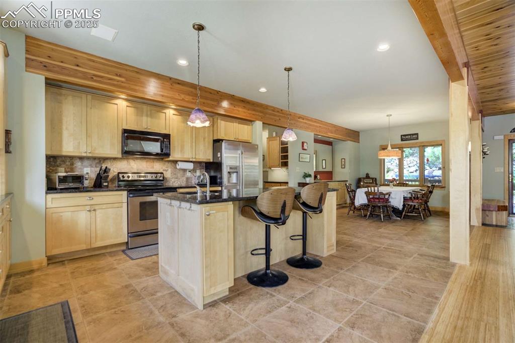 Image 18 of 50: Kitchen featuring the island and bar stools.