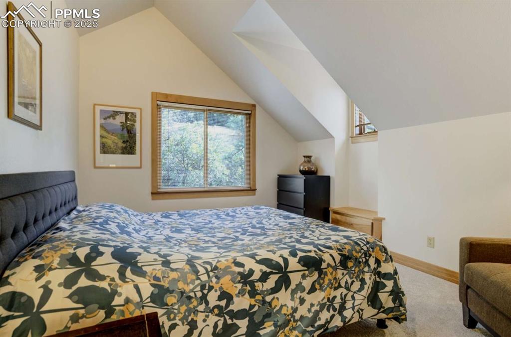 Image 30 of 50: Bedroom with lofted ceiling and carpet