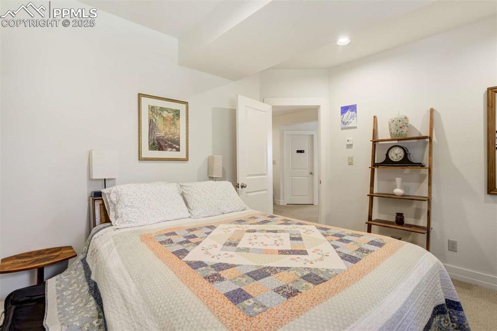 Image 37 of 50: Bedroom with light carpet and recessed lighting