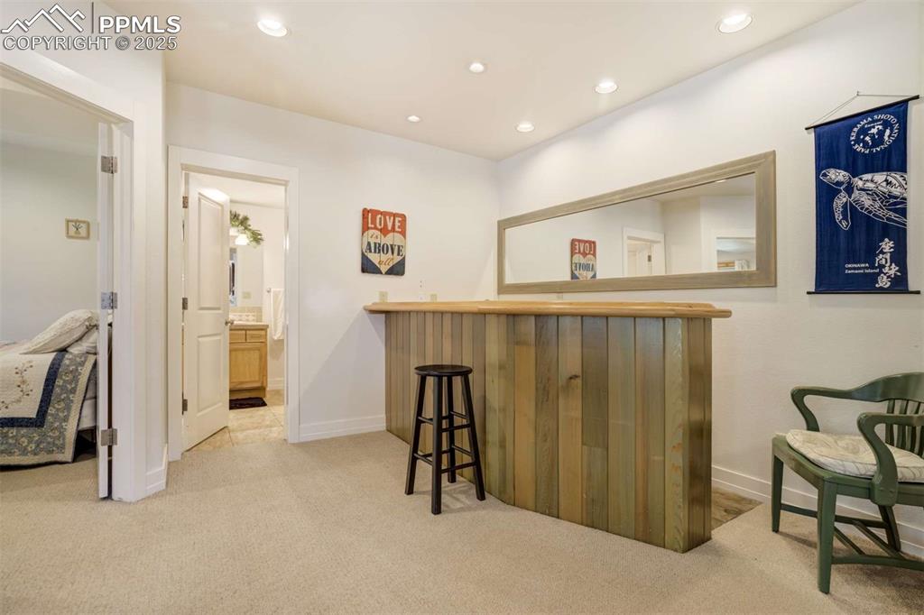 Image 38 of 50: Indoor dry bar featuring carpet flooring and recessed lighting