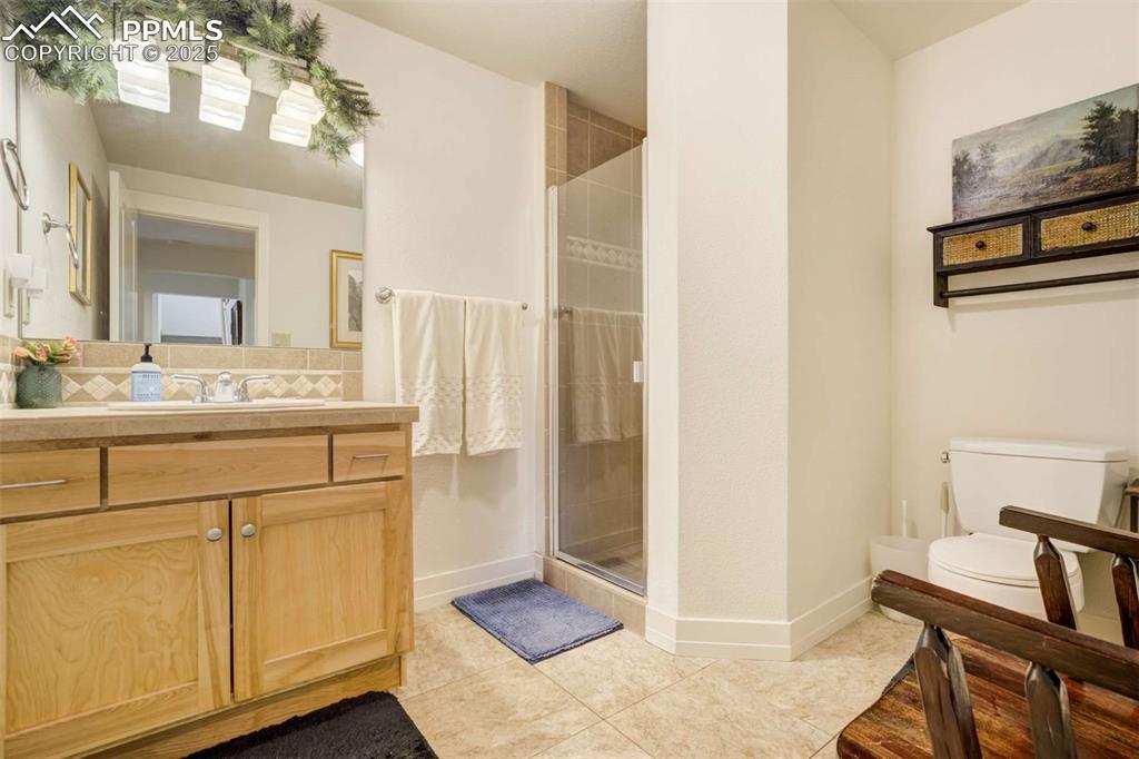 Image 39 of 50: Bathroom featuring a shower stall, vanity, and tile patterned floors