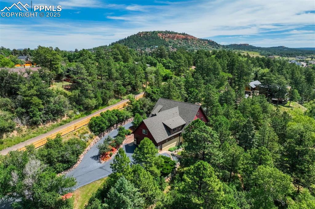 Image 4 of 50: Aerial view of property and surrounding area with a heavily wooded area and