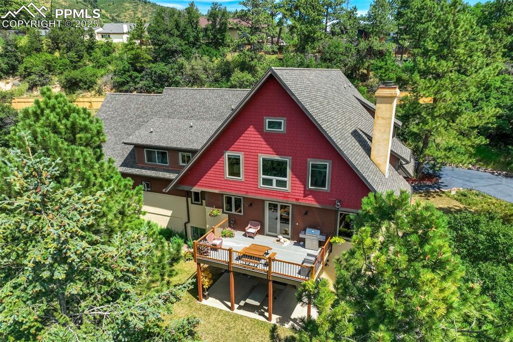 Image 5 of 50: Back of property with a chimney and wooden deck