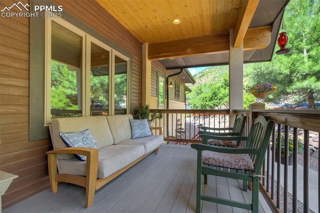 Image 6 of 50: Wooden deck featuring an outdoor living space It also has a trap door in t