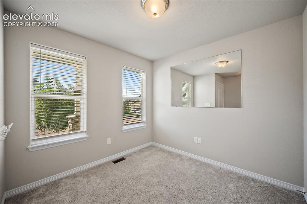 Image 13 of 49: Two windows with blinds, wall-to-wall carpeting, and a built-in wall niche