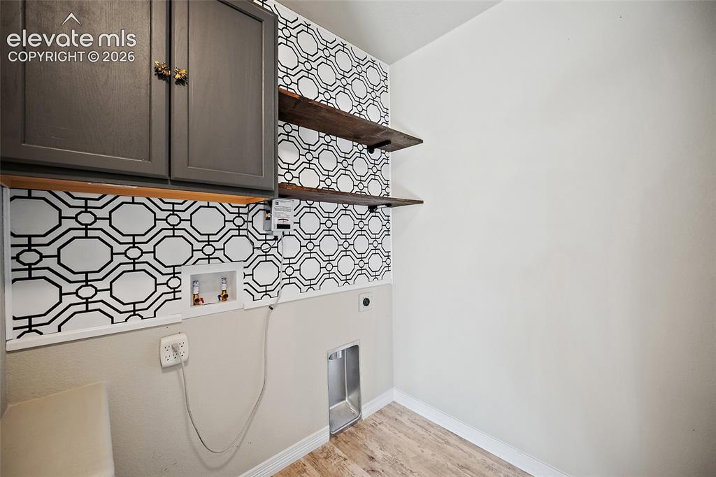 Image 24 of 49: Black and white patterned accent wall, dark gray cabinetry, natural wood-fi