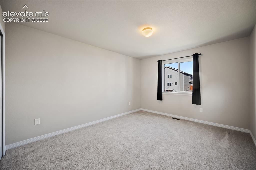 Image 26 of 49: Light-colored carpeting, white wall paint, flush mount ceiling light, and a