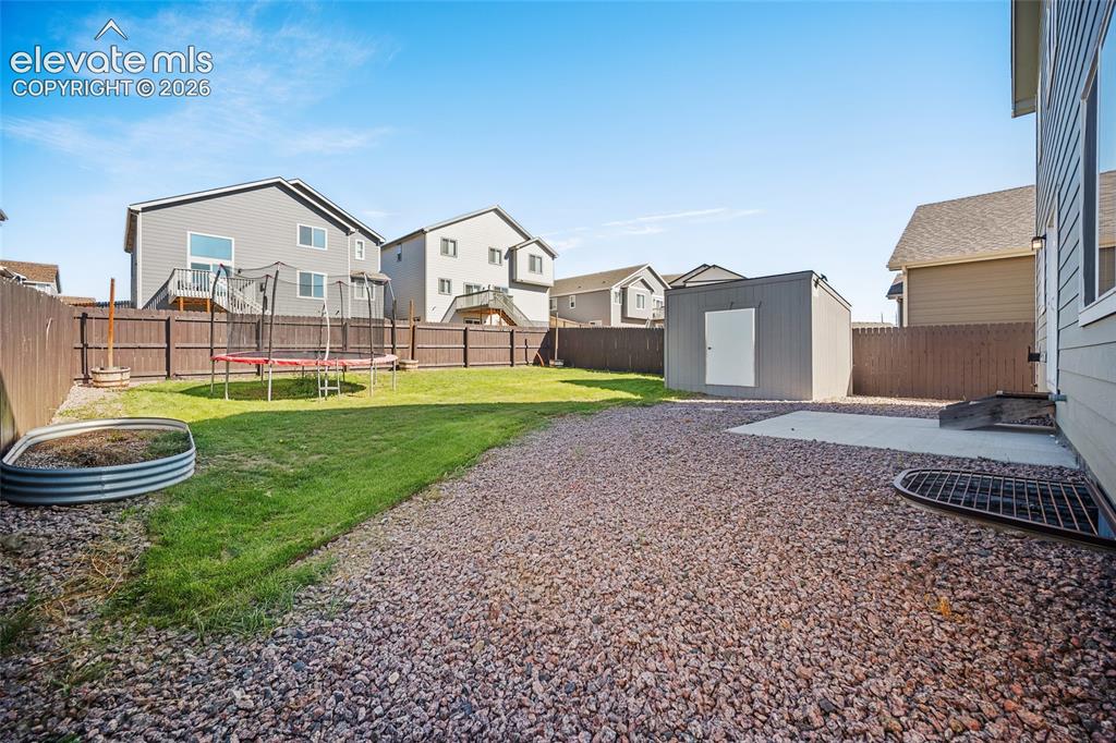 Image 40 of 49: Expansive backyard featuring a manicured lawn, gravel landscaping, a privac