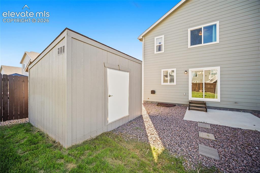 Image 5 of 49: Backyard featuring a shed, sliding glass door, and gravel hardscaping with 