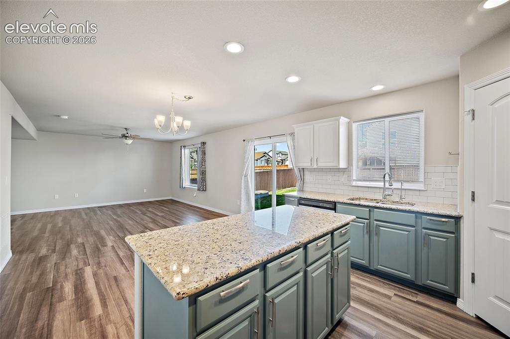 Image 7 of 49: Kitchen featuring an island with a light-toned countertop, two-tone cabinet