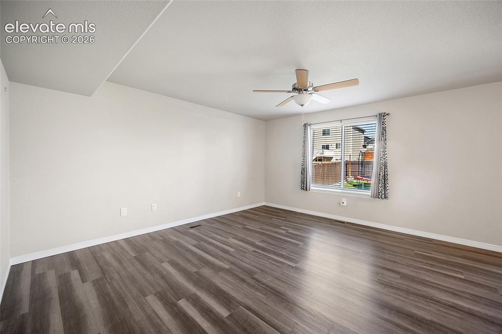 Image 9 of 49: Wood-finish flooring with a neutral wall color, a ceiling fan, and a window