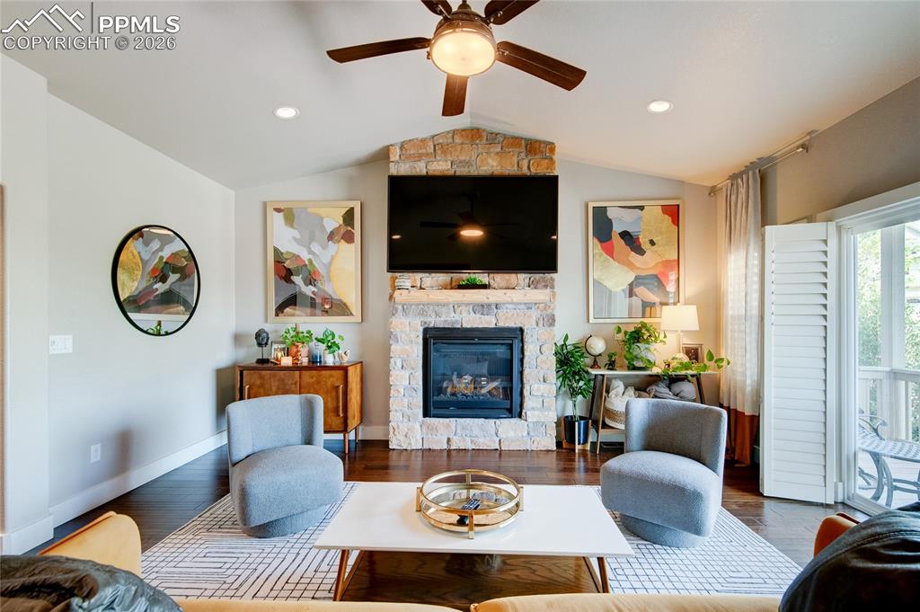 Image 16 of 44: Living room with a gas fireplace, wood finished floors, lofted ceiling, and