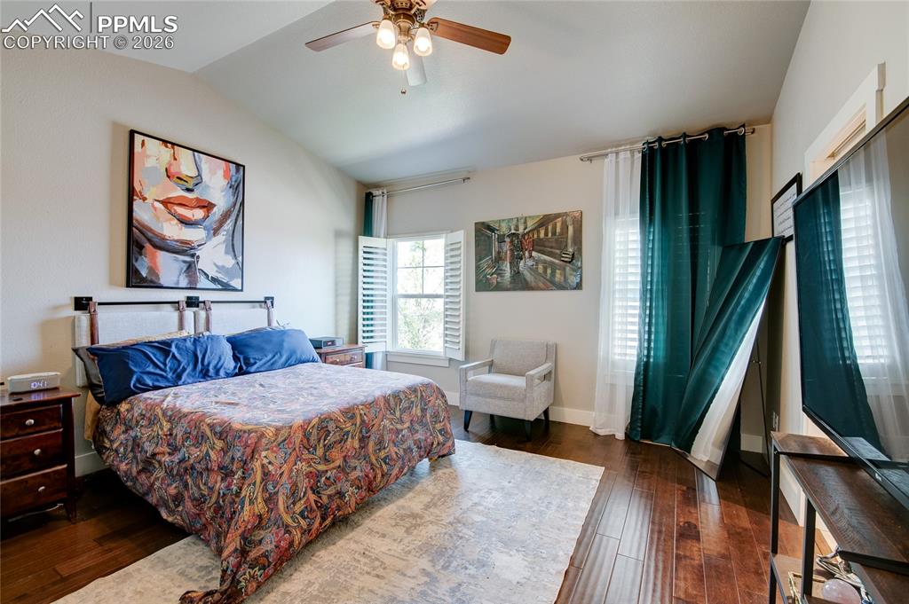 Image 21 of 44: Bedroom with lofted ceiling, dark wood flooring, and a ceiling fan