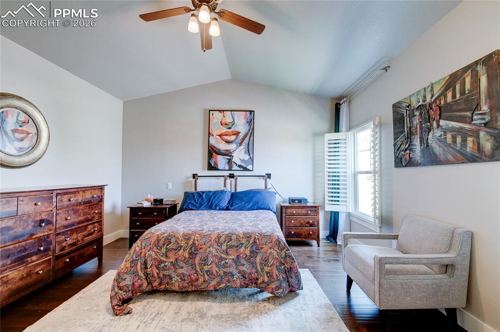 Image 23 of 44: Bedroom with lofted ceiling, ceiling fan, and dark wood finished floors