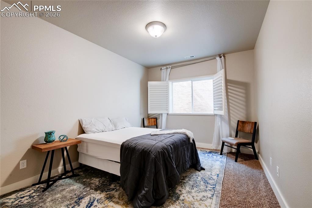 Image 32 of 44: Bedroom featuring baseboards and dark colored carpet